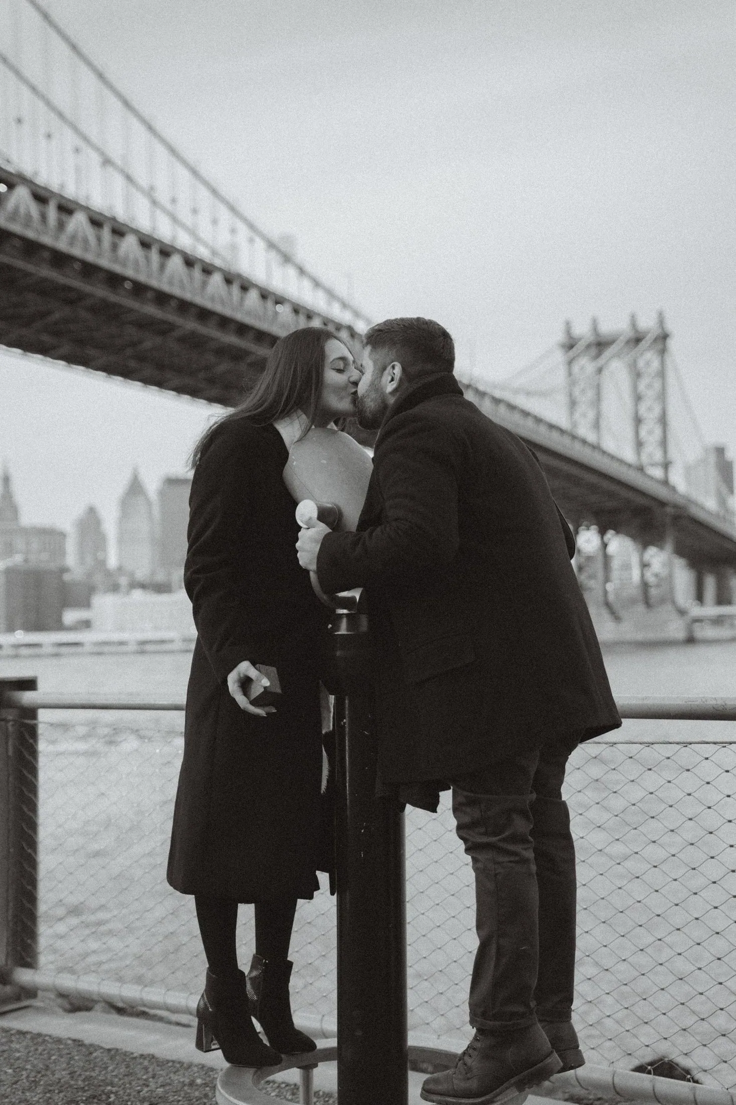 Couple kissing beside the Brooklyn Bridge and Manhattan skyline